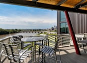 Thumbnail 32 of 42 - A table and chairs are set up on a deck overlooking a river. at Eagle View Lofts, Des Moines, 50309