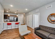 Thumbnail 26 of 31 - A living room with a grey couch and a white chair.
