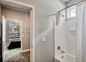Thumbnail 29 of 31 - A bathroom with a shower and a window.
