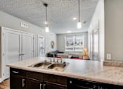 Thumbnail 6 of 31 - A kitchen with a marble countertop and a sink.