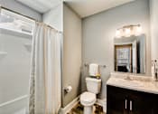 Thumbnail 19 of 31 - A bathroom with a toilet, sink, and shower.