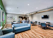 Thumbnail 22 of 31 - A living room with a blue couch and wooden floors.