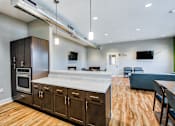 Thumbnail 12 of 31 - A modern kitchen with wooden floors and stainless steel appliances.