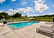 Thumbnail 5 of 31 - A pool surrounded by a concrete patio and lounge chairs.