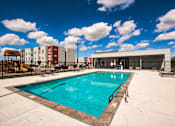 Thumbnail 4 of 31 - A large swimming pool in a sunny outdoor setting.