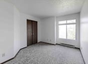 Thumbnail 13 of 66 - A room with a carpeted floor, a window with blinds, and a door.