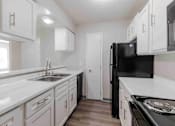 Thumbnail 11 of 66 - A kitchen with black appliances and white cabinets.