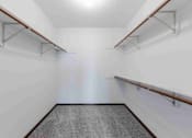 Thumbnail 14 of 66 - A long, narrow hallway with a grey carpeted floor and white walls.