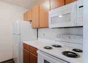 Thumbnail 22 of 66 - A white microwave oven is mounted above a white stove in a kitchen.