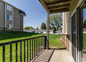 Thumbnail 65 of 66 - A balcony with a black railing and a view of a grassy area and other buildings.