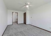 Thumbnail 5 of 66 - A room with a ceiling fan and carpeted floor.