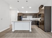 Thumbnail 31 of 52 - A modern kitchen with dark wood cabinets and stainless steel appliances.