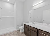 Thumbnail 32 of 52 - A white bathroom with a toilet, sink, and shower.