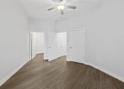Thumbnail 41 of 52 - A room with a ceiling fan and wooden flooring.