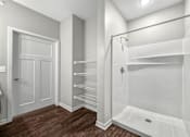 Thumbnail 27 of 32 - A white bathroom with a walk in shower and a towel bar at The Barclay Apartments, Altoona, IA