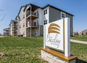 Thumbnail 31 of 32 - an apartment building with a sign in the grass at The Barclay Apartments, Altoona, IA, 50009