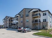 Thumbnail 32 of 32 - A large apartment complex with a parking lot in front at The Barclay Apartments, Altoona, IA