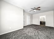 Thumbnail 18 of 32 - A room with a ceiling fan and carpeted floor at The Barclay Apartments, IOWA, 50009