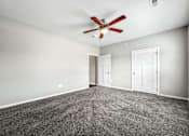 Thumbnail 19 of 32 - an empty room with carpet and a ceiling fan at The Barclay Apartments, Altoona, IA, 50009