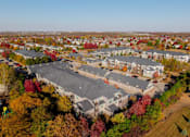 Thumbnail 42 of 50 - An aerial view of a residential area with apartment buildings and trees in autumn colors. at Stonegate Crossing Apartments, Clive, IOWA