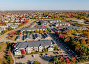 Thumbnail 46 of 50 - A bird's eye view of a residential area with houses and trees in autumn colors at Stonegate Crossing Apartments, IOWA
