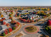 Thumbnail 43 of 50 - A roundabout in a suburban area with trees showing autumn colors. at Stonegate Crossing Apartments, Clive
