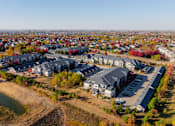 Thumbnail 45 of 50 - A bird's eye view of a residential area with houses and a parking lot at Stonegate Crossing Apartments, Clive