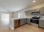 Thumbnail 11 of 34 - A modern kitchen with stainless steel appliances and wooden floors.at Linc, Des Moines  