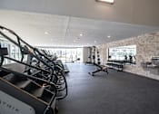Thumbnail 27 of 34 - A gym with a row of treadmills on the left and a row of exercise bikes on the right.at Linc, Des Moines, 50309  