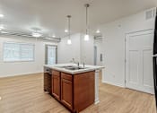 Thumbnail 34 of 35 - A kitchen with a wooden island and white countertop at Melbourne Apartments, Des Moines