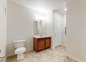 Thumbnail 14 of 35 - A white toilet sits in a bathroom next to a sink and medicine cabinet at Melbourne Apartments, Iowa, 50320