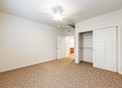 Thumbnail 12 of 35 - A room with a carpeted floor and a ceiling fan at Melbourne Apartments, Georgia