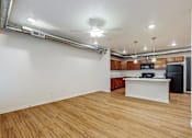 Thumbnail 17 of 35 - A kitchen area with a white counter and wooden flooring at Melbourne Apartments, IA, 50320