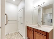 Thumbnail 26 of 35 - A bathroom with a sink, mirror, and a white door at Melbourne Apartments, Georgia
