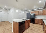 Thumbnail 30 of 35 - A kitchen with wooden cabinets and a black refrigerator at Melbourne Apartments, Des Moines, IA