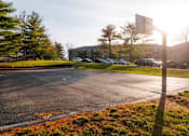 Thumbnail 45 of 90 - A parking lot with a basketball hoop in the background. at Rosemont Place Apartments, Iowa, 50320