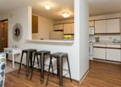 Thumbnail 9 of 90 - a living room with three bar stools and a kitchen at Rosemont Place Apartments, Des Moines, 50320