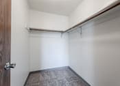 Thumbnail 31 of 90 - A small, empty room with a brown door and a grey carpet. at Rosemont Place Apartments, Iowa, 50320