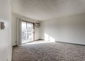 Thumbnail 30 of 90 - A room with a carpeted floor and a sliding glass door leading to a balcony at Rosemont Place Apartments, Des Moines, Iowa