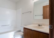 Thumbnail 19 of 90 - A white bathroom with a toilet, sink and bathtub at Rosemont Place Apartments, Des Moines, IA, 50320