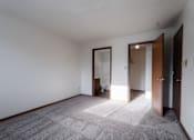 Thumbnail 21 of 90 - A room with a carpeted floor and a door on the right at Rosemont Place Apartments, Des Moines, 50320