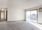 Thumbnail 39 of 90 - A room with a carpeted floor and a sliding glass door leading to a balcony at Rosemont Place Apartments, Iowa