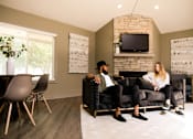 Thumbnail 14 of 90 - a man and woman sitting on a couch in a living room at Rosemont Place Apartments, Des Moines, IA, 50320