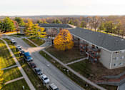 Thumbnail 56 of 90 - A parking lot with cars and a building in the background at Rosemont Place Apartments, Iowa, 50320