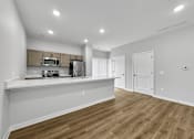 Thumbnail 14 of 30 - a kitchen and living room with a counter top and a refrigerator at Soll, Des Moines Iowa   