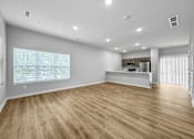 Thumbnail 3 of 30 - the living room and kitchen of a new home with wood flooring at Soll, Des Moines  