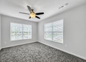 Thumbnail 17 of 30 - an empty bedroom with a ceiling fan and two windows at Soll, Des Moines, IA 50312  