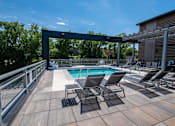 Thumbnail 22 of 30 - the pool on the rooftop of a building with lounge chairs at Soll, Des Moines, IA 50312  