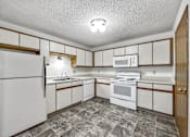 Thumbnail 17 of 21 - a kitchen with white appliances and wooden cabinets at Somerset Apartments, Des Moines, IA, 50315