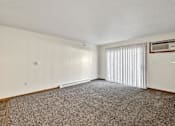 Thumbnail 11 of 21 - A room with a carpeted floor and a window with blinds at Somerset Apartments, Des Moines, Iowa